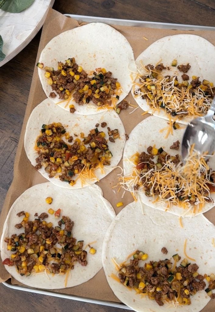 Flour tortillas with the ground chicken, veggies and cheese topping