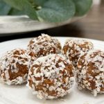 A plate with five carrot cake energy balls on top of it