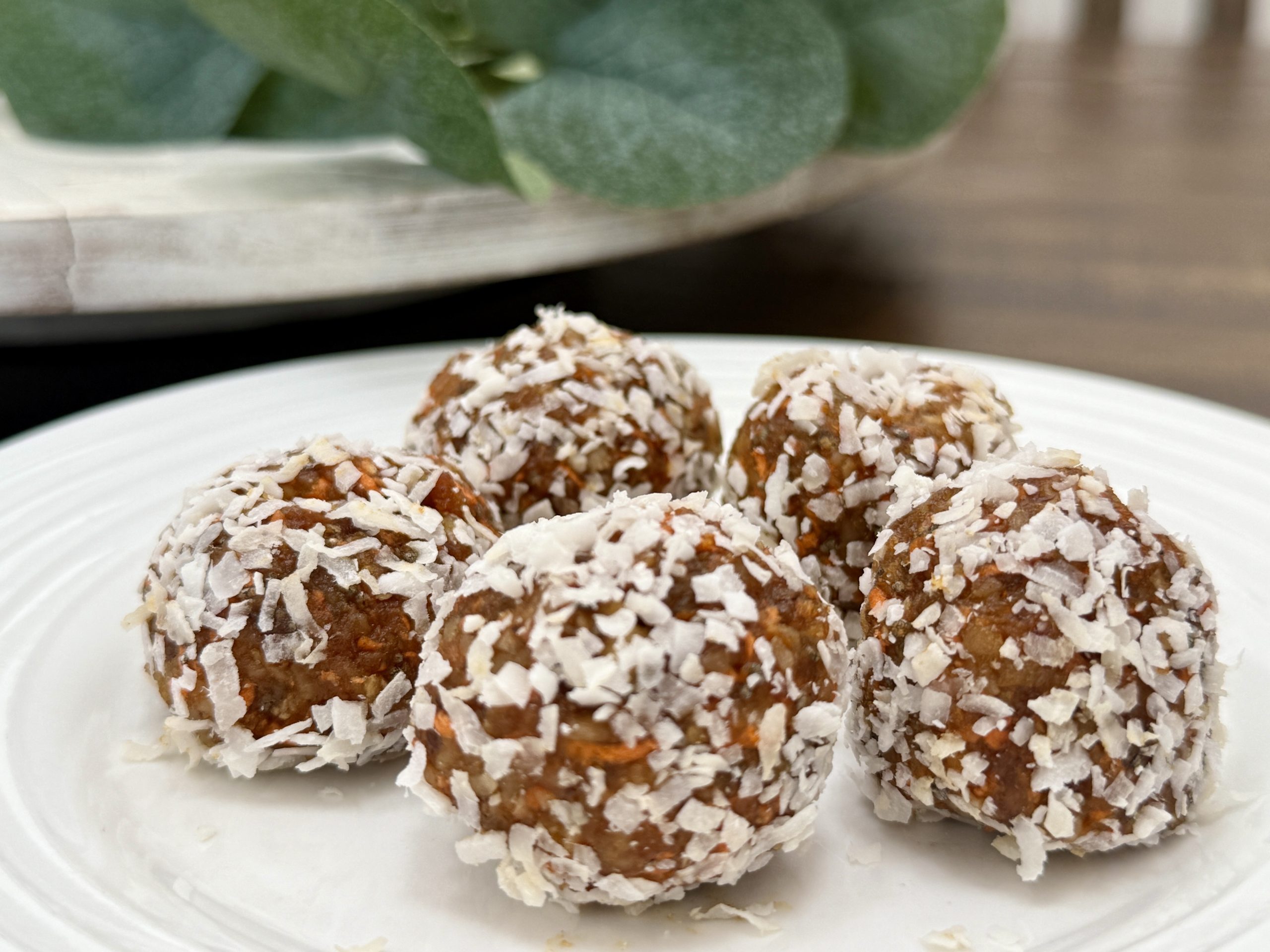 A plate with five carrot cake energy balls on top of it