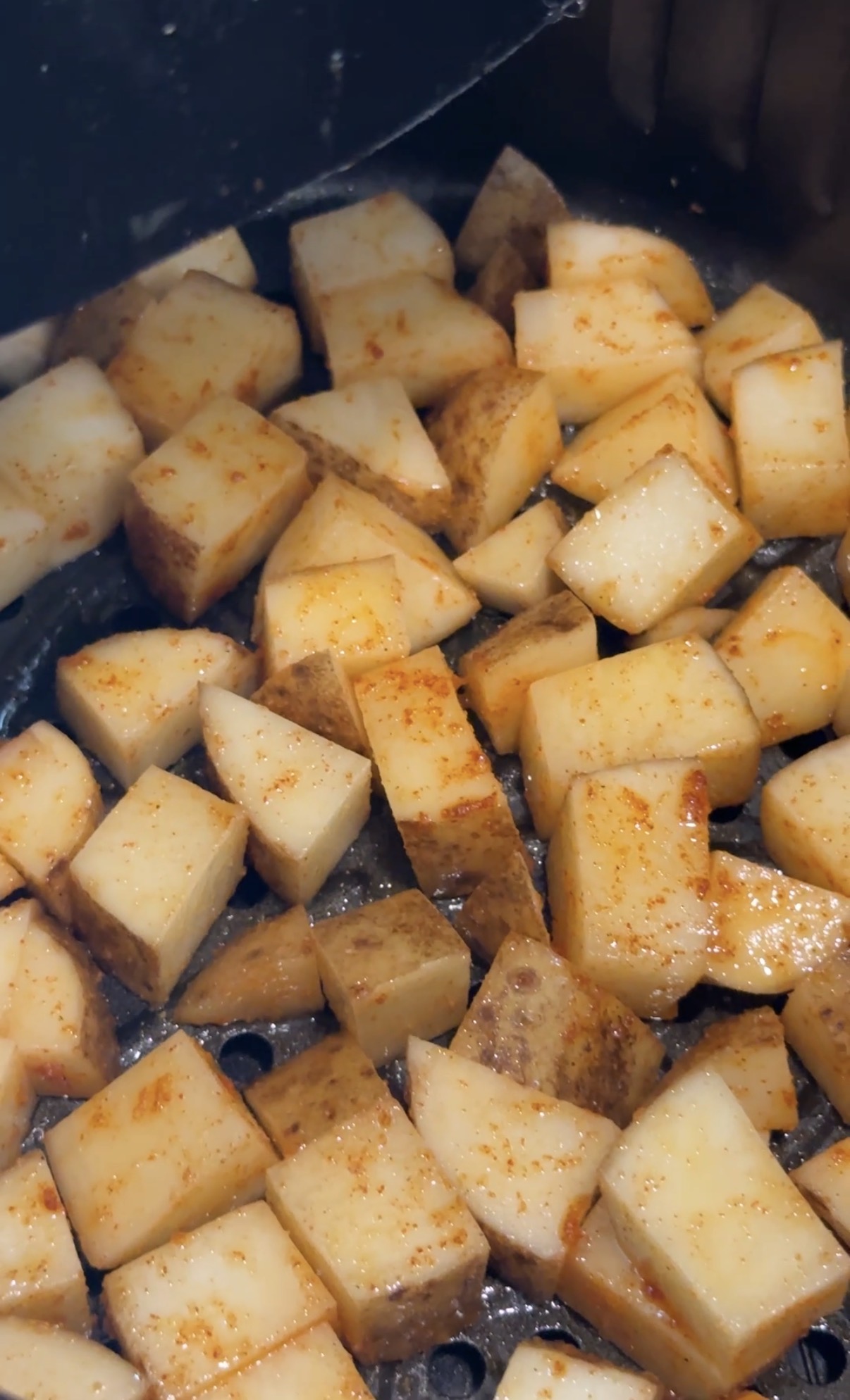 Diced potatoes seasoned with olive oil, salt, paprika and garlic powder in the air fryer