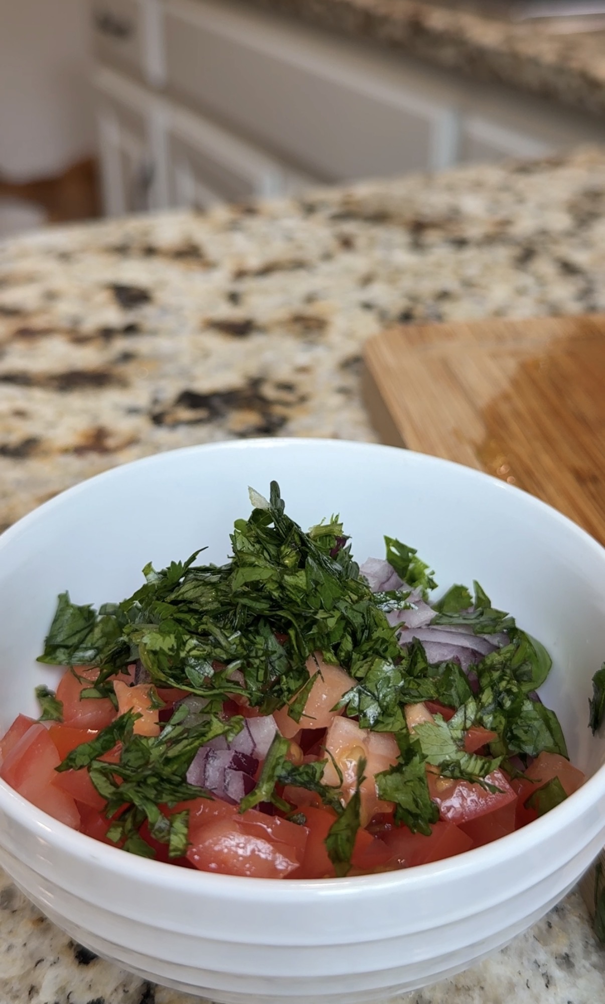 a bowl with pico de gallo ingredients: tomatoes, red onion, cilantro and lime juice