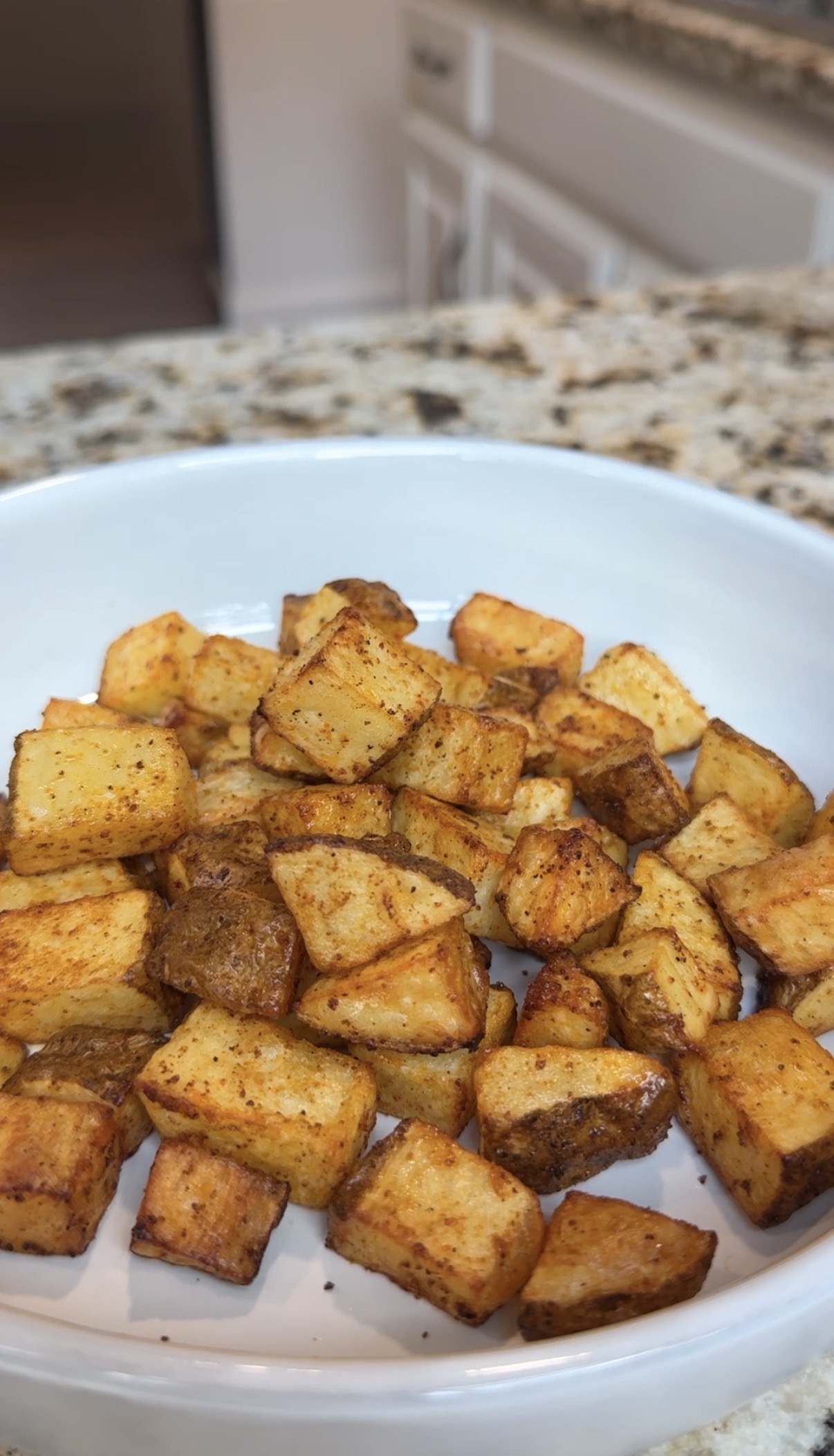 Crispy air fryer diced potatoes in a white bowl