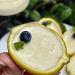 Halved lemon, filled with cream and lemon mixture and topped with one blueberry