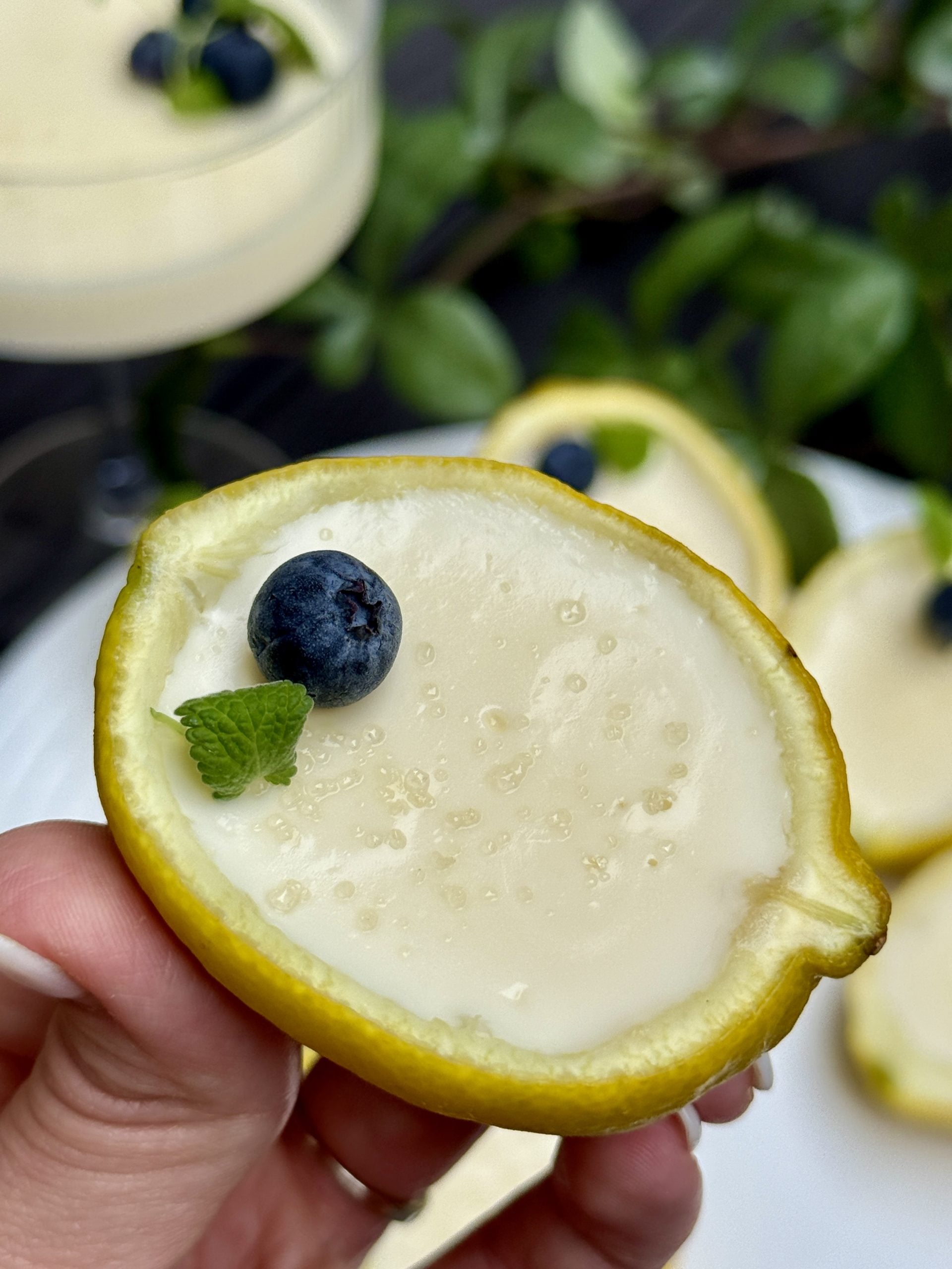 Halved lemon, filled with cream and lemon mixture and topped with one blueberry