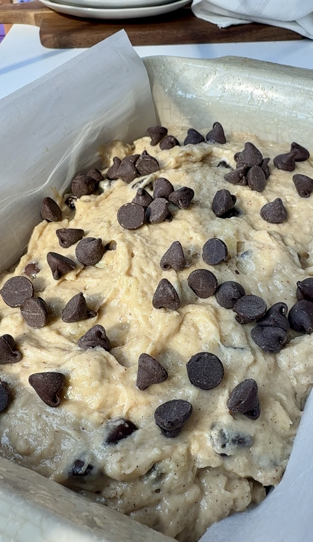Baking pan with unbaked banana bread batter topped with chocolate chips.