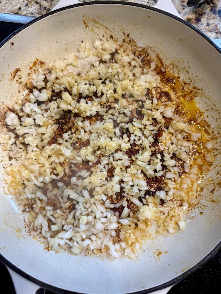 Orzo and seasonings added to the skillet. 