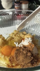Mashed bananas, eggs, greek yogurt, cacao powder in a glass bowl
