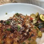 A bowl with chicken thigh and veggies