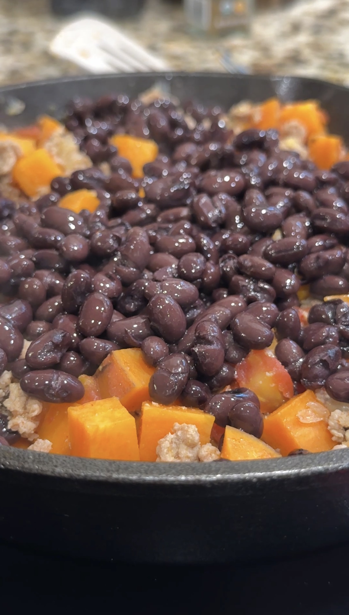 A skillet with ground turkey, sweet potatoes, and black beans