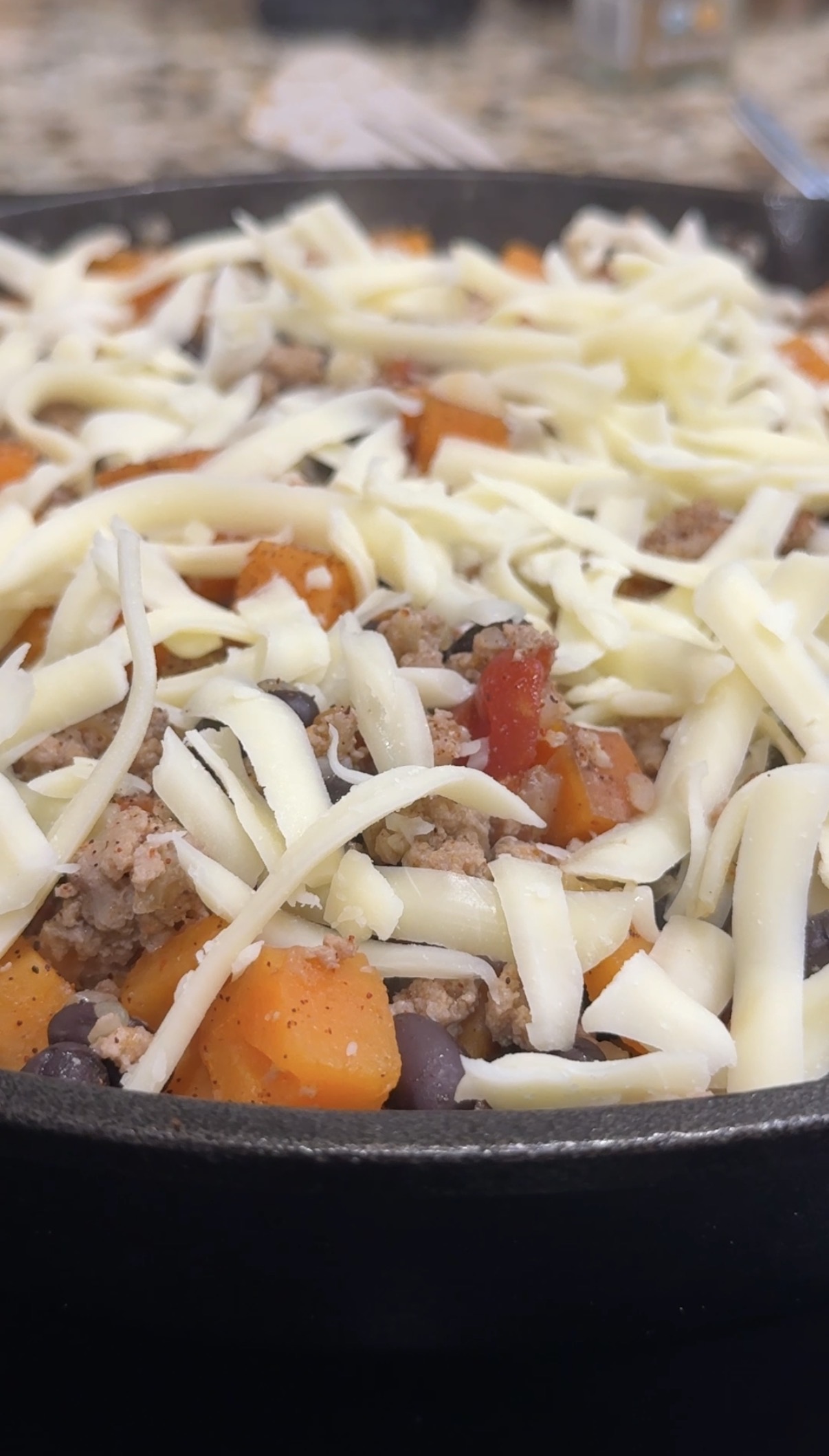 Sweet potato, ground turkey and black beans skillet, topped with shredded cheese