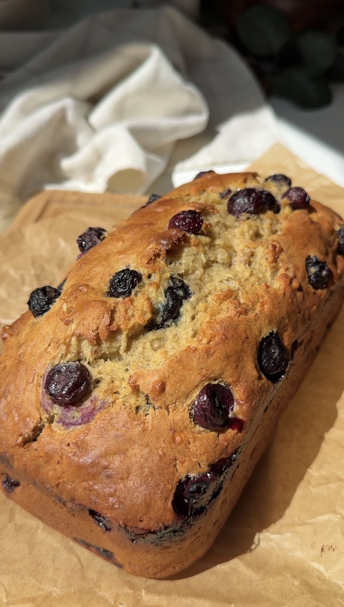 Blueberry banana nut loaf removed from pan and resting on a piece of parchment.