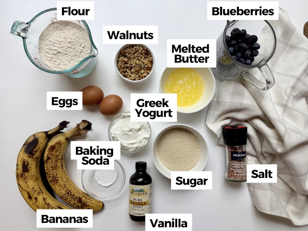 Ingredients to make a healthier blueberry banana nut bread in bowls with text labels.