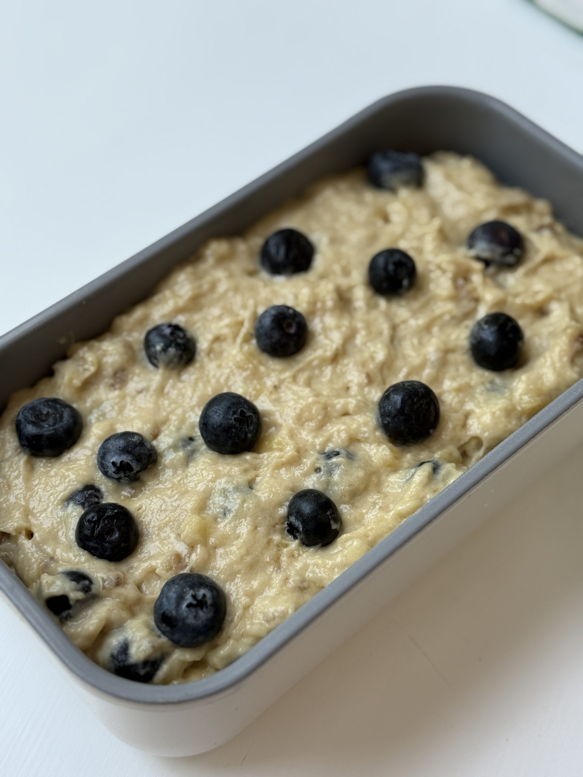 Batter transferred to a loaf pan and blueberries added on top.