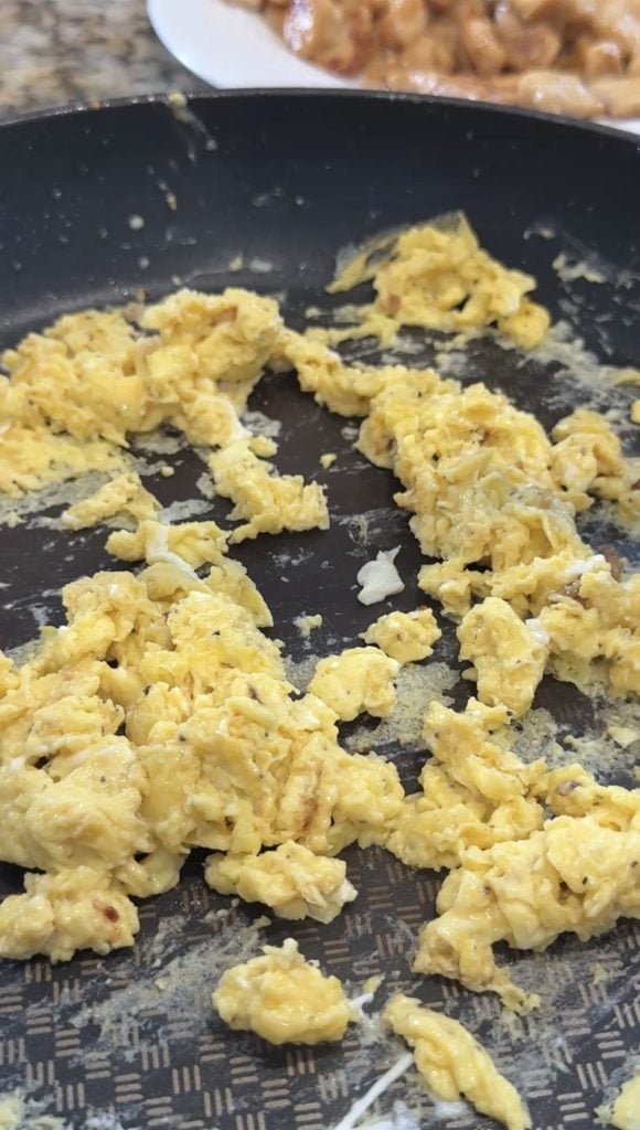 Cooking scrambled eggs in a pan. 