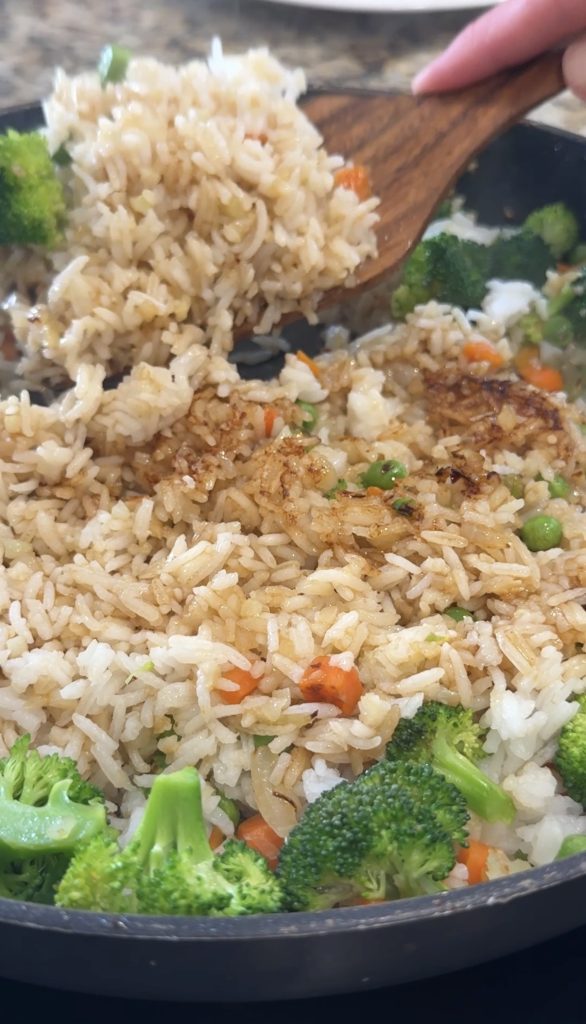 Adding the rice and meat to the skillet to cook. 