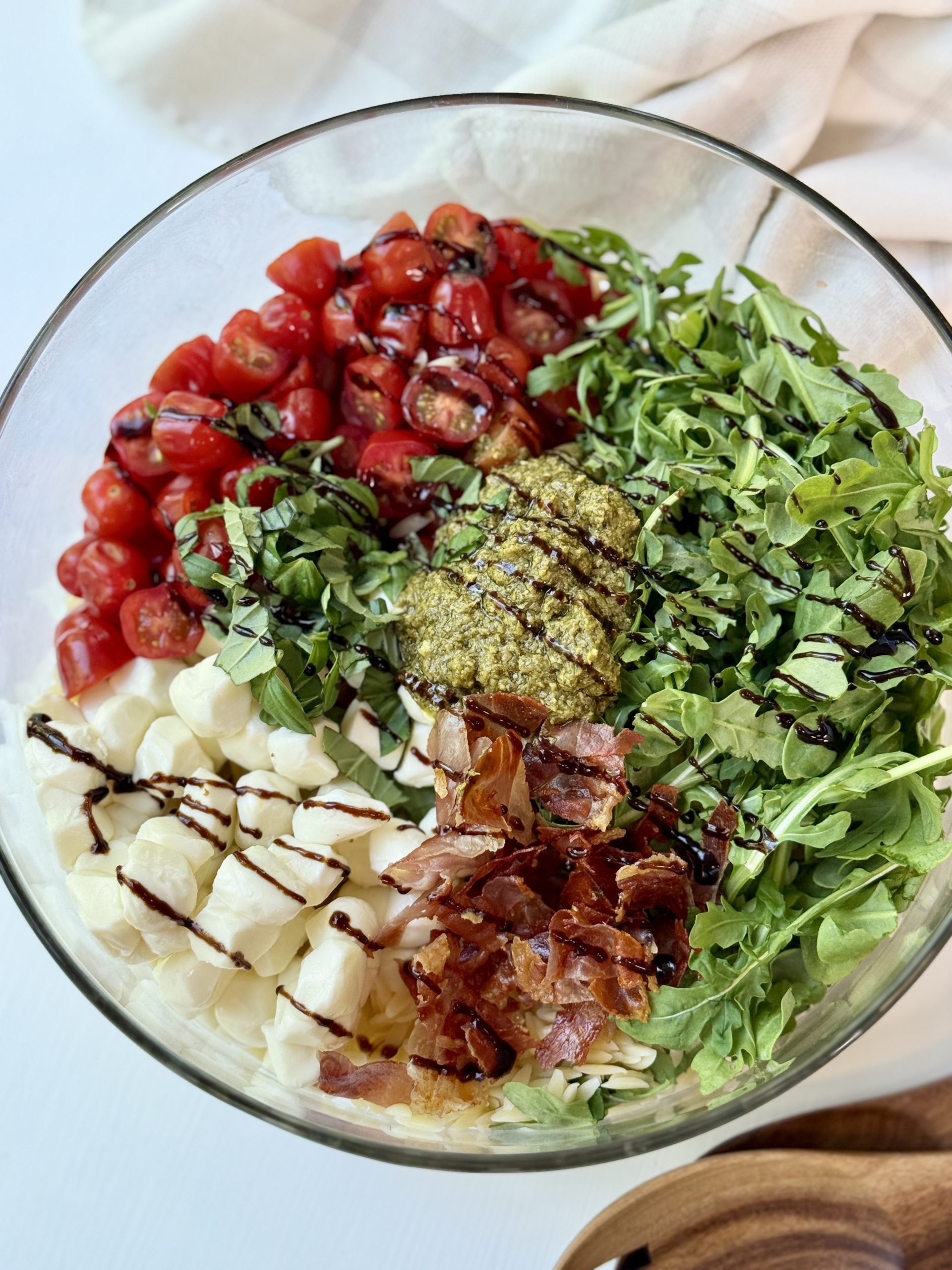 Balsamic glaze drizzled over the top of the pesto orzo salad.