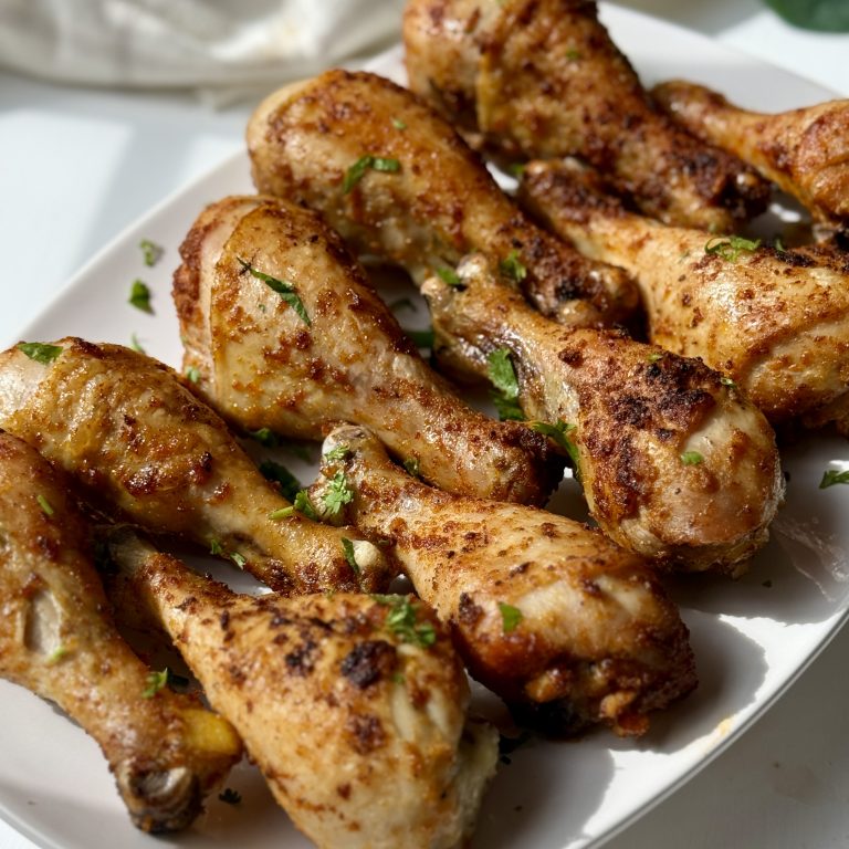 Oven baked chicken drumsticks on a platter.