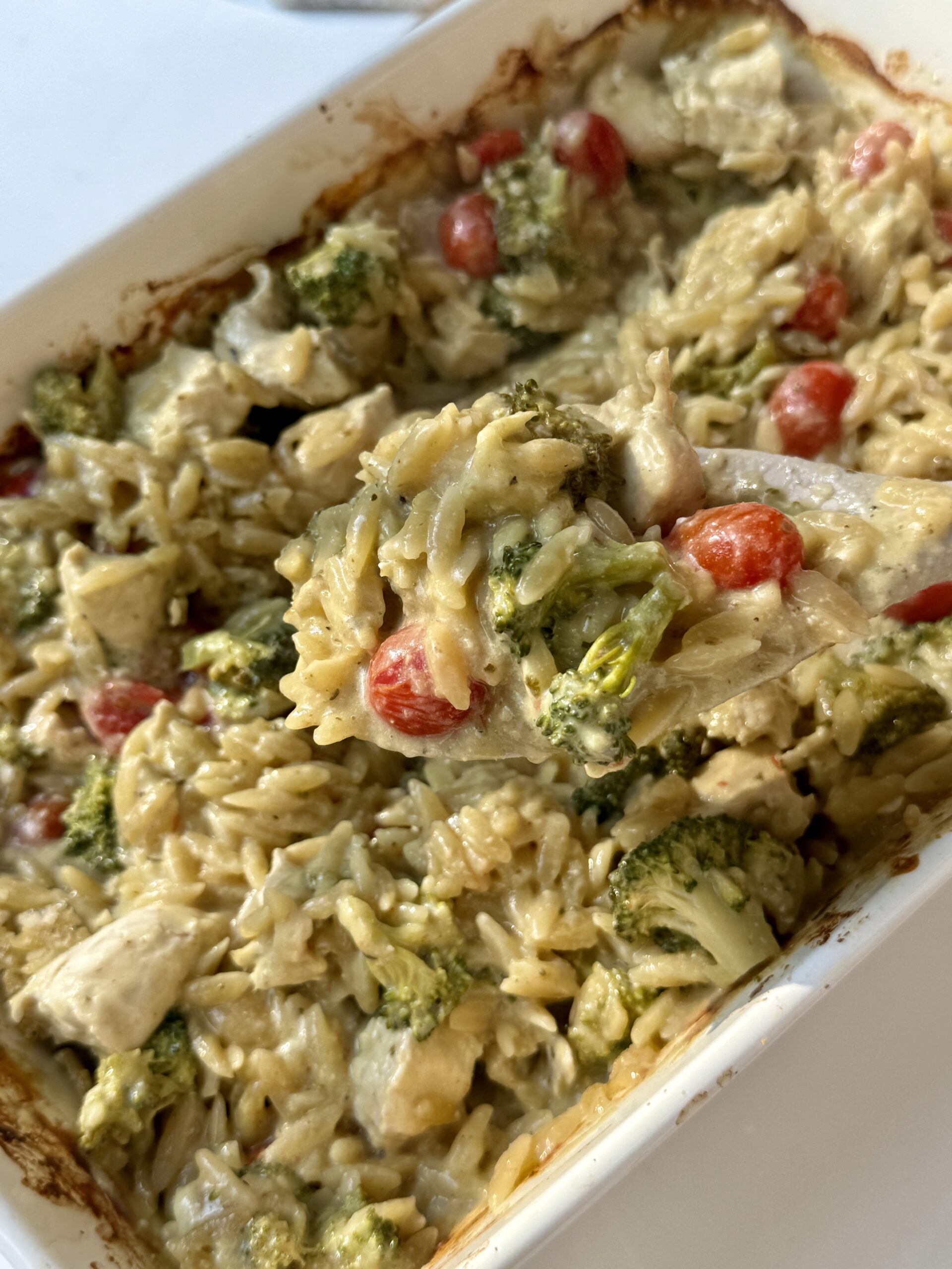Chicken orzo bake in a white baking dish.