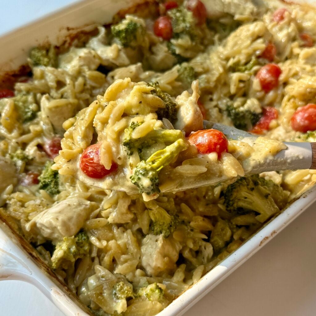 Pesto chicken orzo bake in a white baking dish.