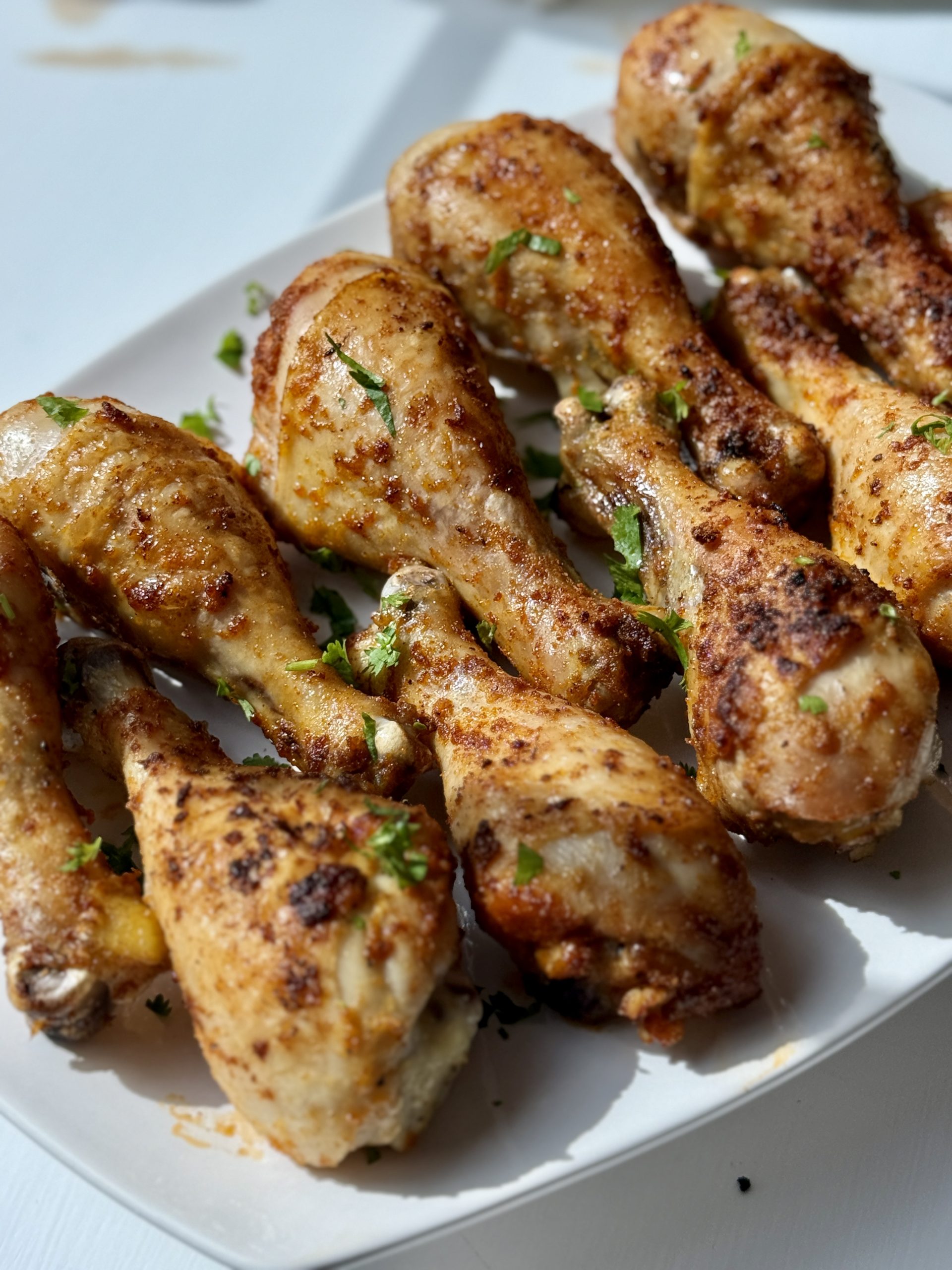A platter of oven baked chicken drumsticks.