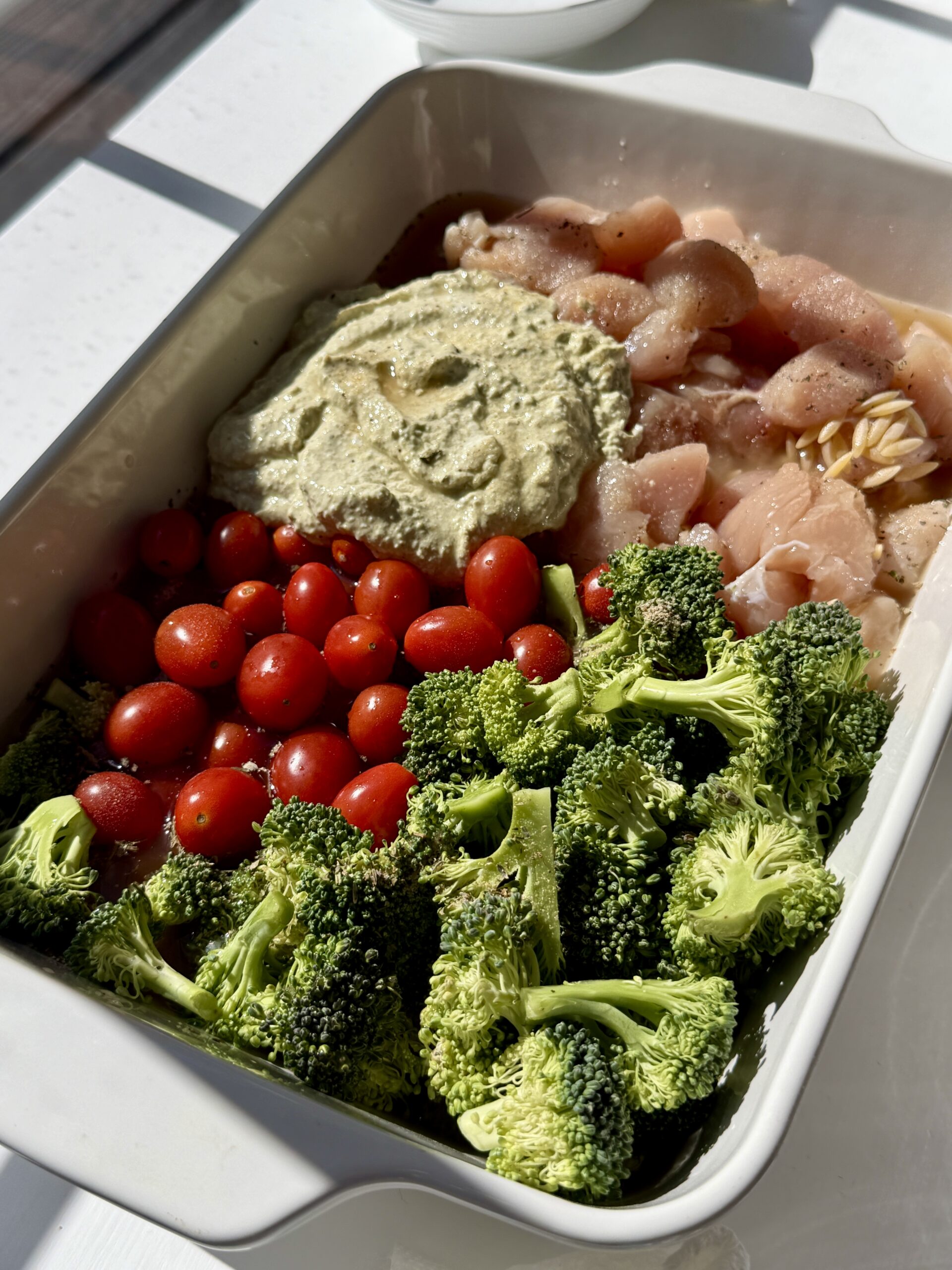 All the ingredients to make chicken orzo casserole in the dish.