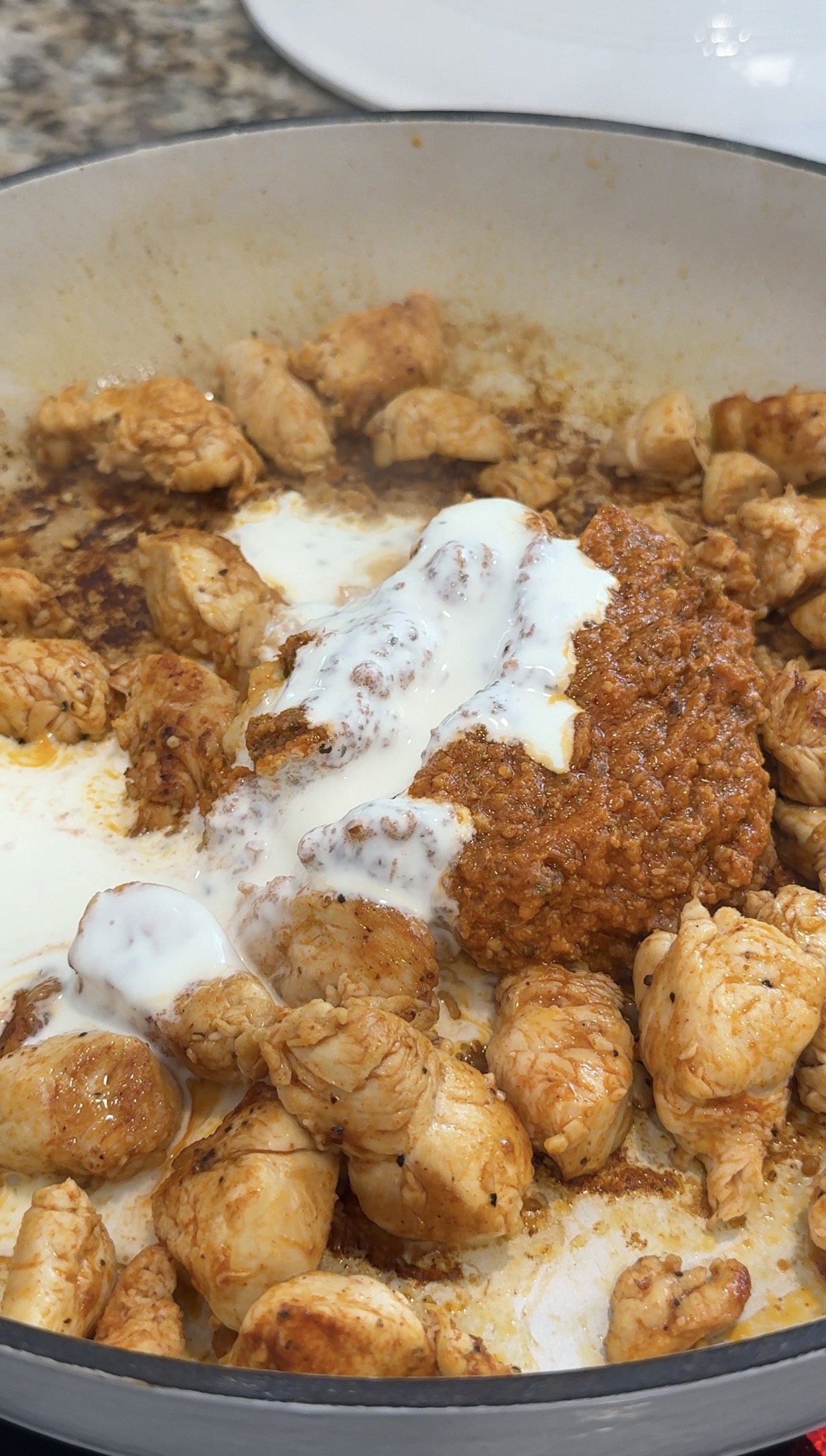 Red pesto and heavy cream added to the skillet. 