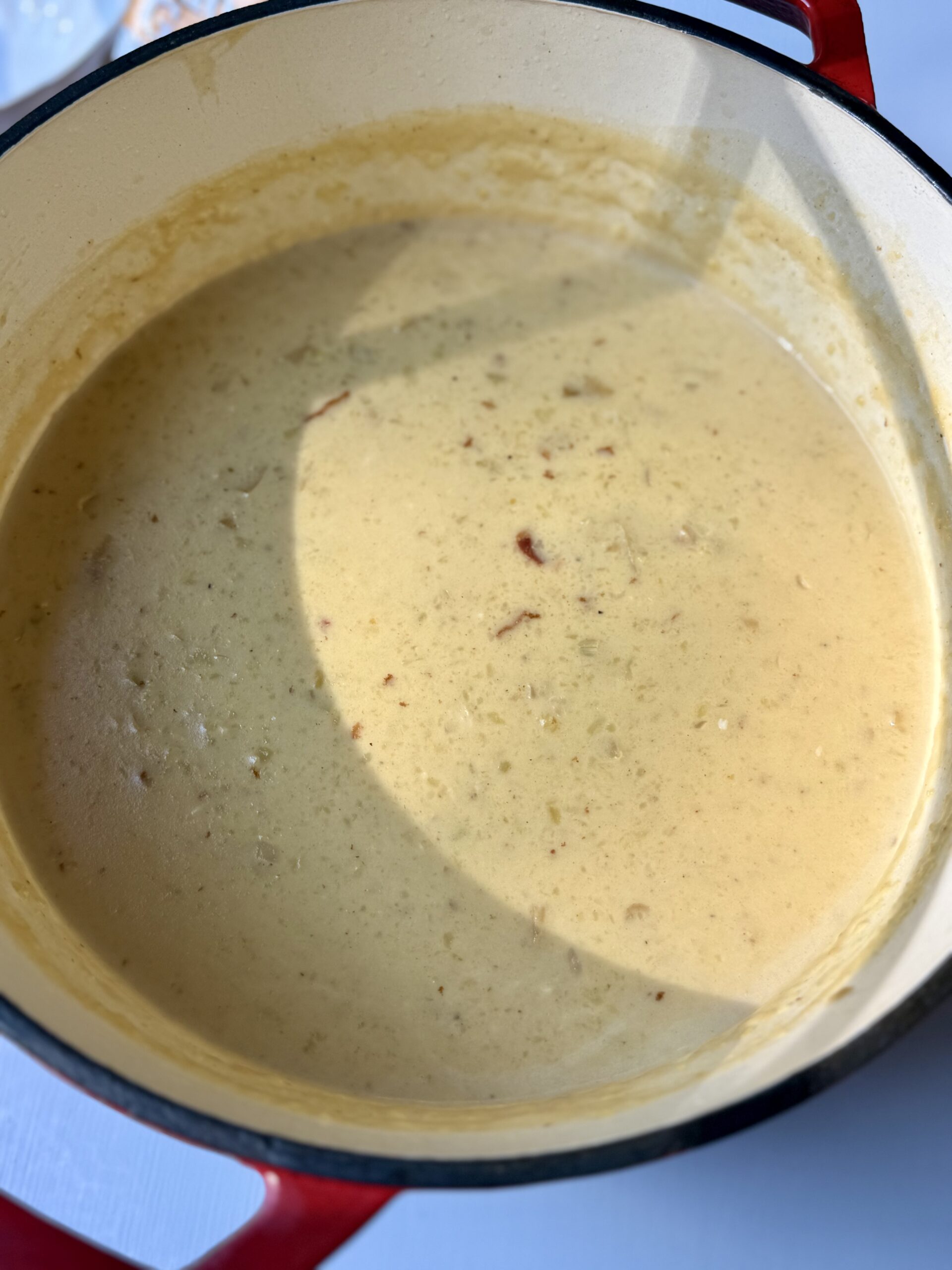 Creamy potato soup simmering in a Dutch oven with tender potatoes