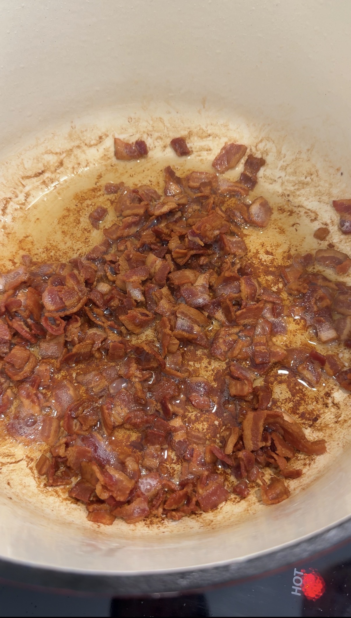 Crispy bacon cooking in a dutch oven