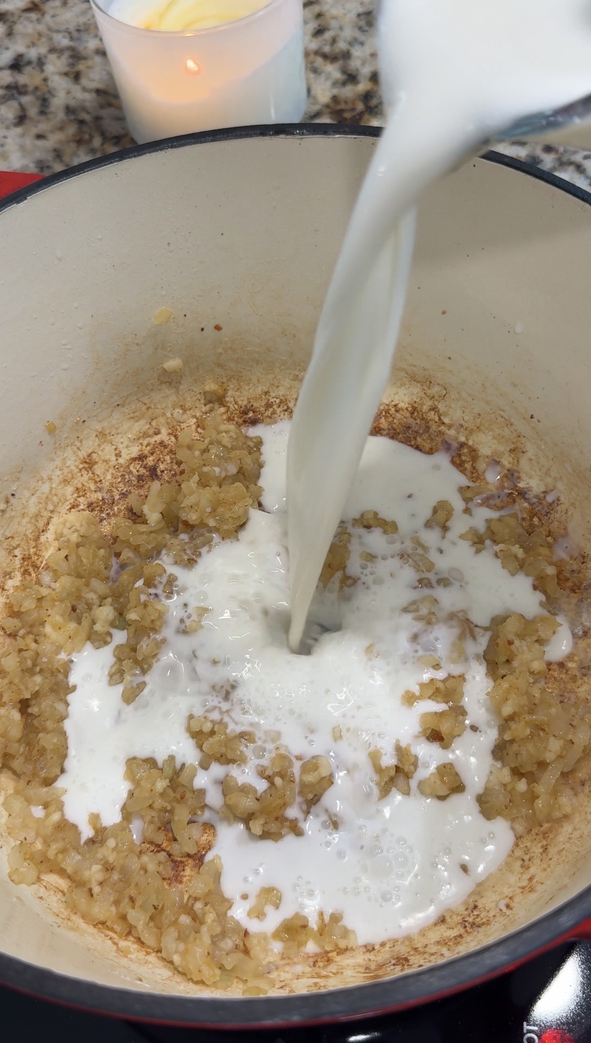 Milk being added to the diced onions and garlic