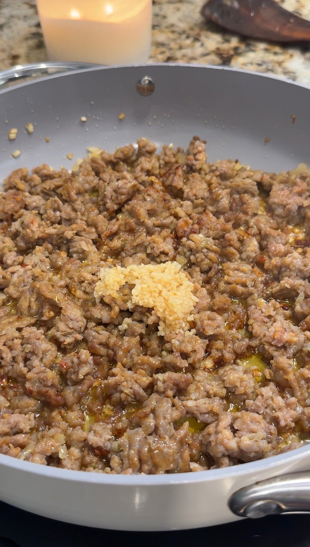 Italian sausage, diced onion and minced garlic cooking in a large skillet