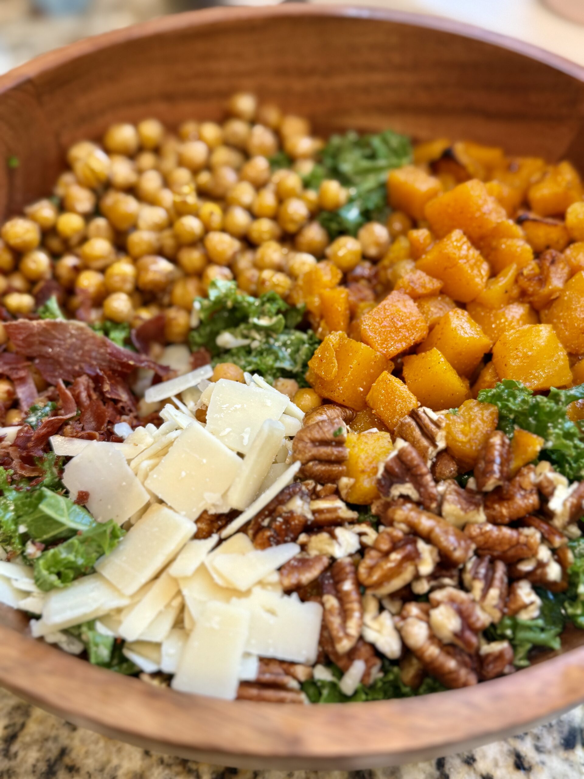 Harvest salad with roasted butternut squash, crispy chickpeas, kale, prosciutto, pecans, Parmesan, and lemon tahini dressing