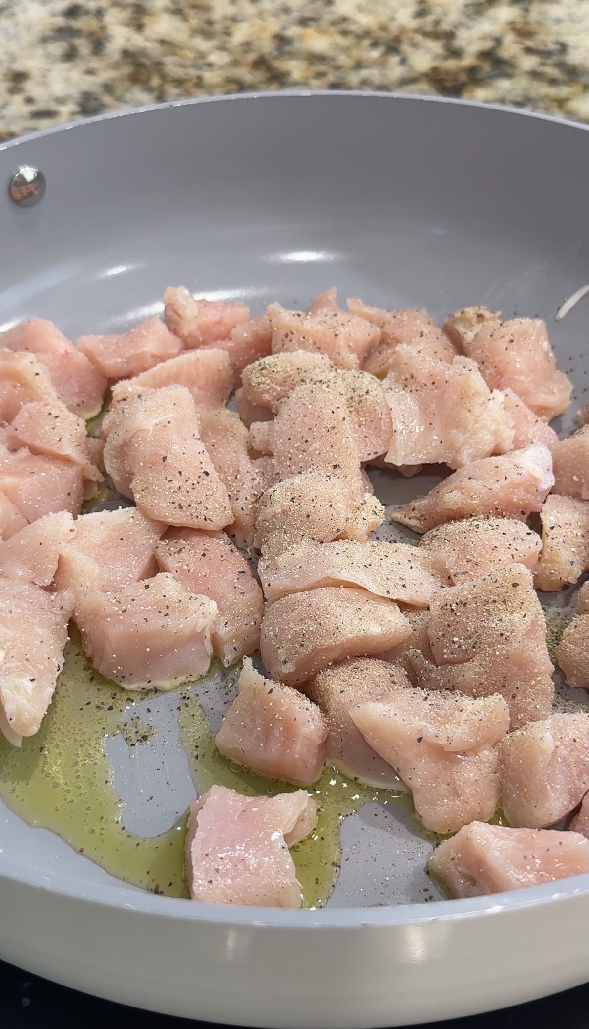 Seasoned chicken in a skillet.