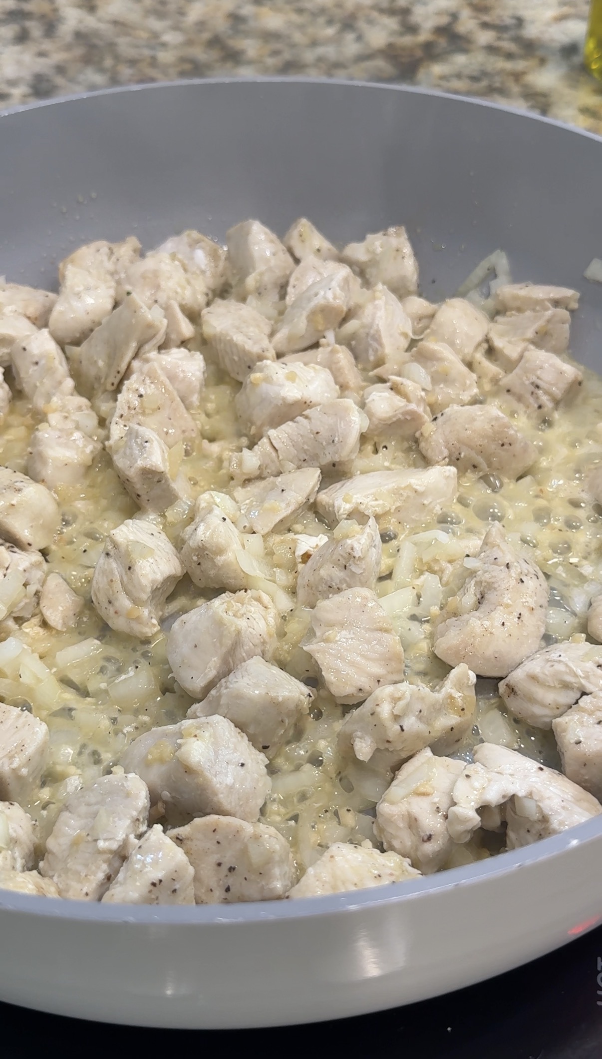 Aromatics added to the skillet with the chicken.