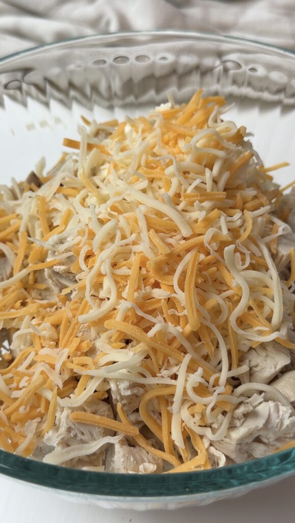Chicken enchilada filling ingredients added to a bowl. 