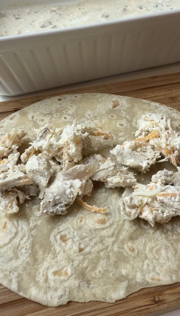 Filling spread out on a flour tortilla.