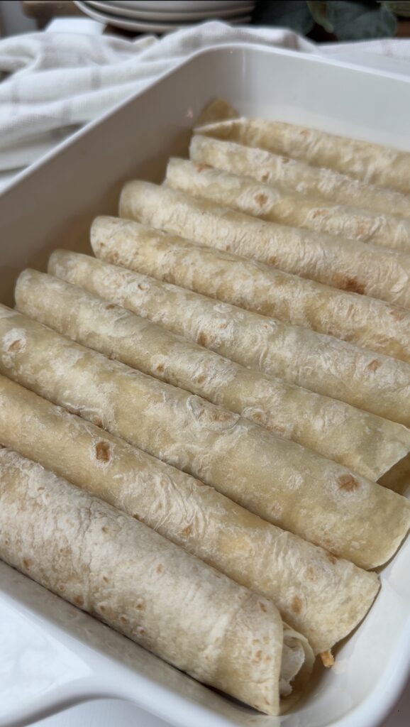 Tortillas rolled and in a baking dish.