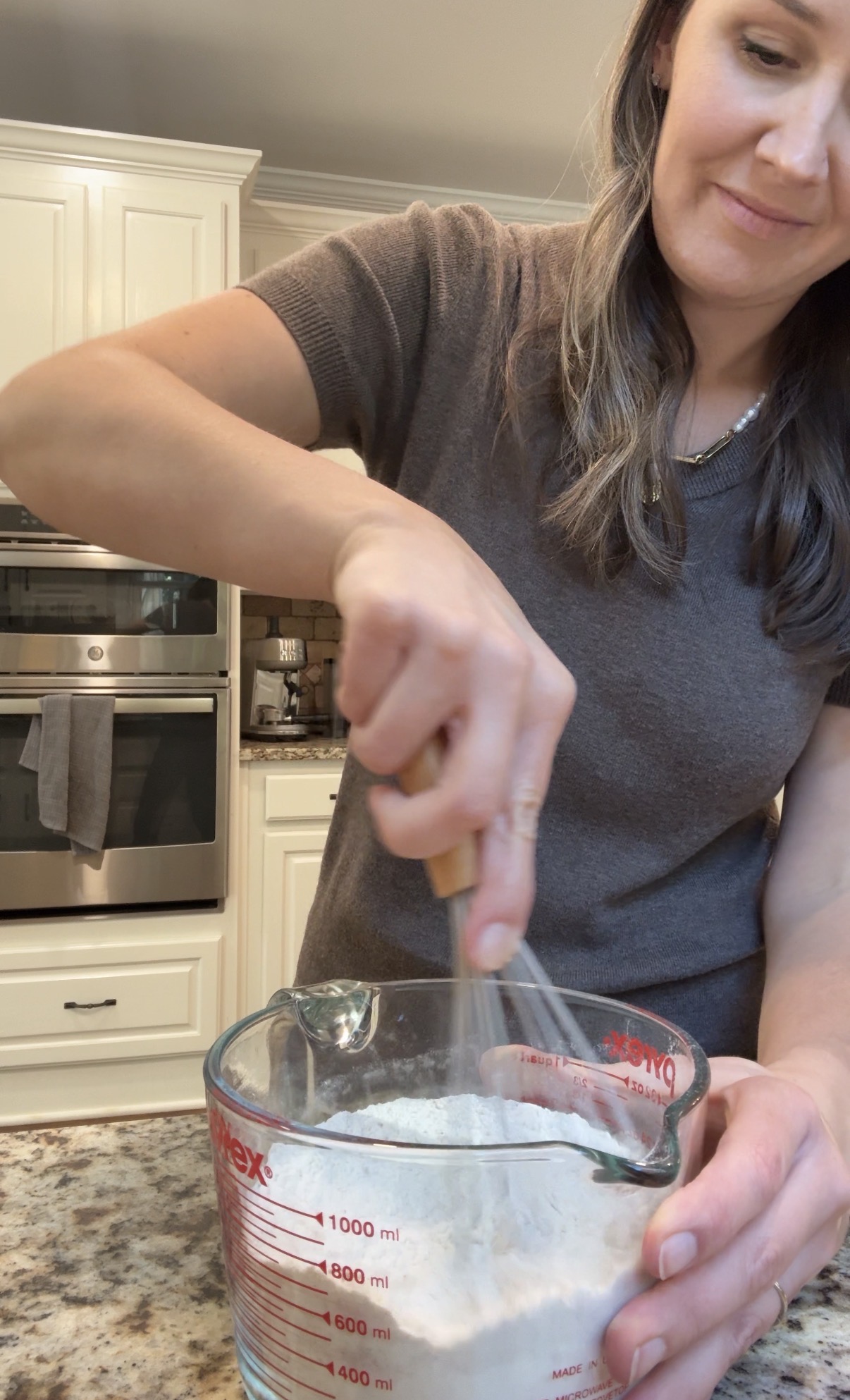 dry ingredients being mixed together in a glass mixing bowl