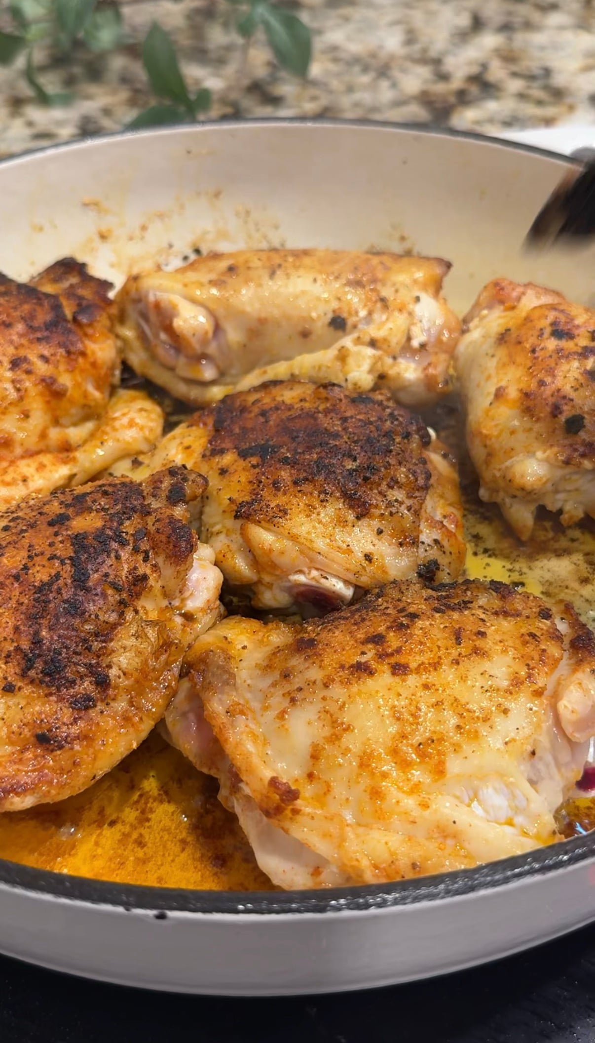 Chicken thighs browning in a skillet before cooking with rice and butternut squash